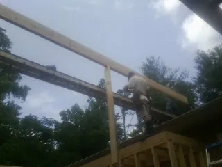 Carpenter setting a ridge beam over a new addition frame — Ice Dam Removal by Roofing Brothers in Macungie