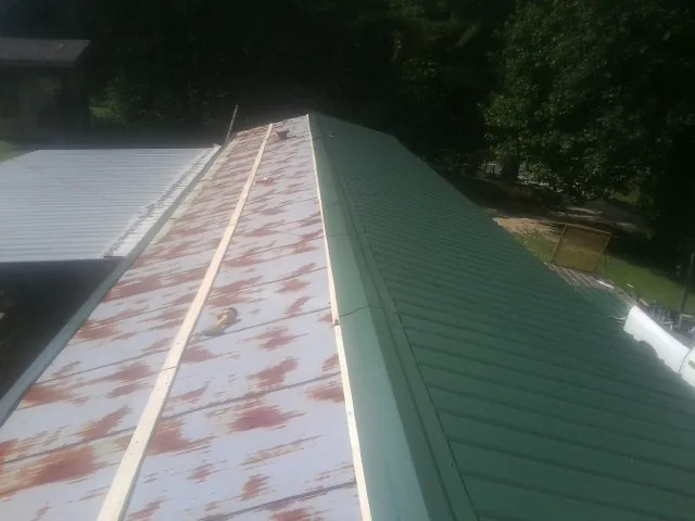Old rusted panels beside newly installed green metal roofing — Wind Damage Roof Repair by Roofing Brothers in Macungie
