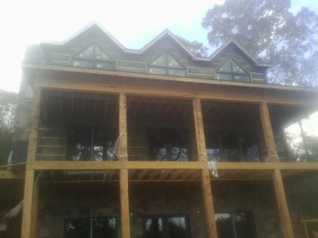 Dormers and porch framing on a large log home under construction — Roof Coating work by our crew in Macungie