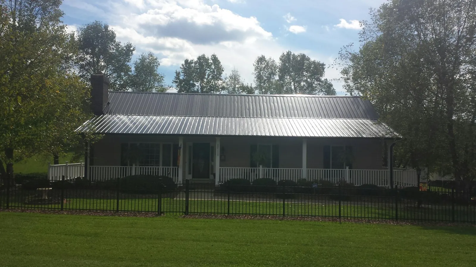 Gray metal roof on a brick ranch with a full width front porch — Gutter Guard Installation work by our crew in Macungie