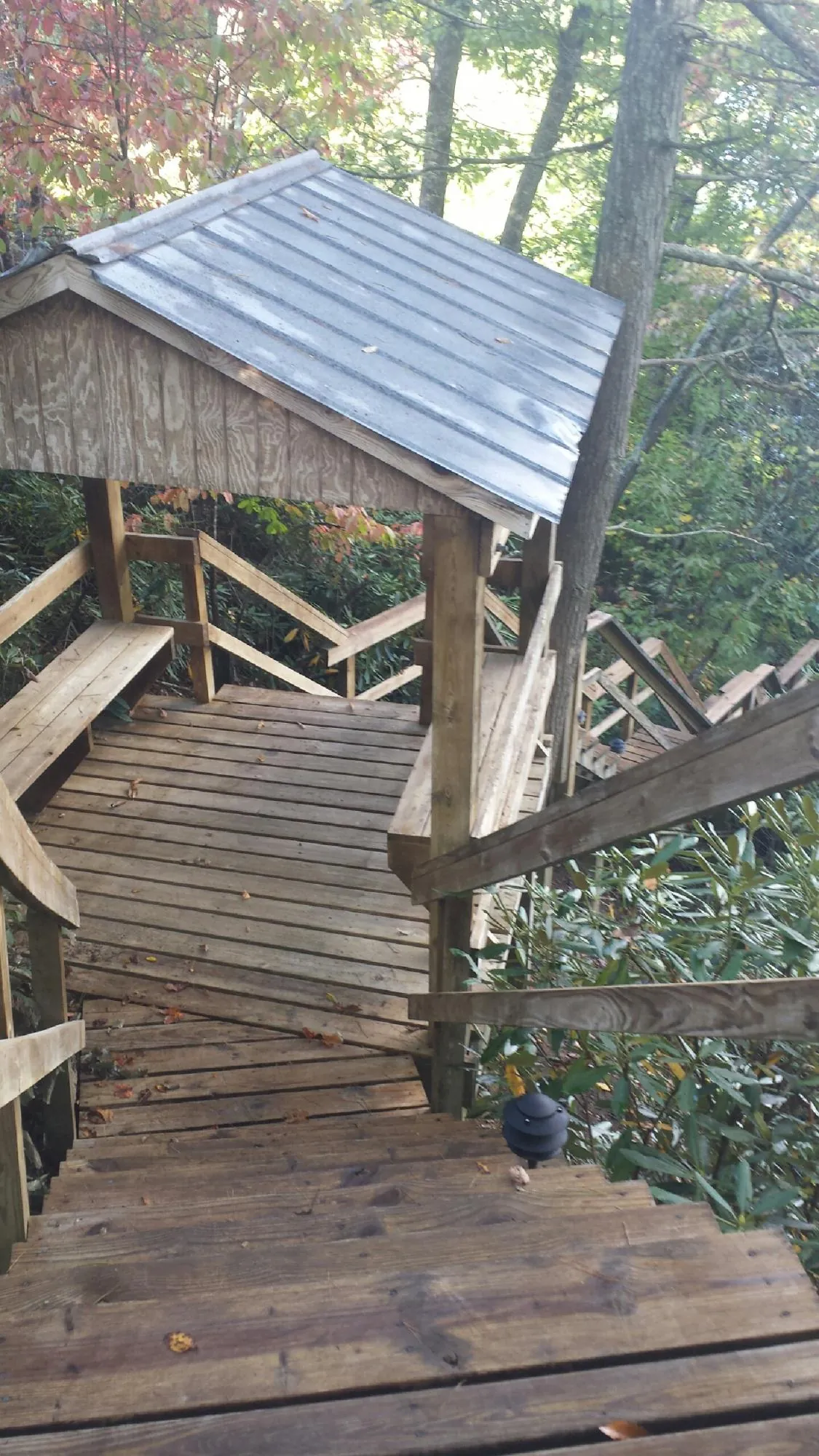 Metal roofed shelter over wooden steps on a wooded walkway — Skylight Repair & Installation work by our crew in Macungie